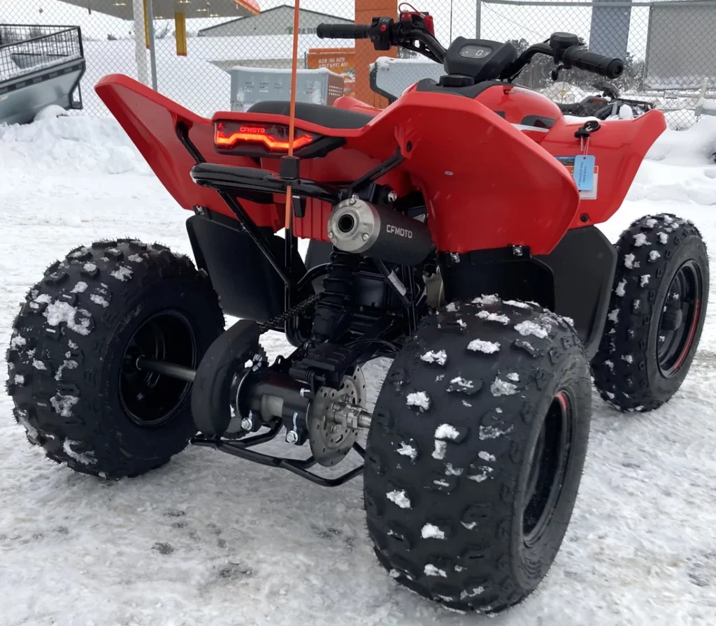 Röd fyrhjuling för barn fotograferad snett bakifrån